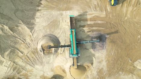 cargadora de ruedas con cucharón en piedra de carga frontal en trituradora, toma aérea de drones