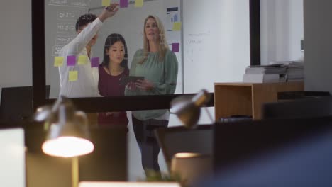 video of diverse female and male coworkers brainstorming, working late in office