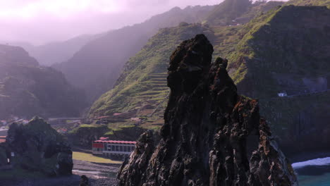 Toma-Aérea-En-órbita-De-Una-Gigantesca-Formación-Rocosa-Rodeada-De-Montañas-Místicas-Y-El-Océano-Atlántico-En-Madeira,-Portugal