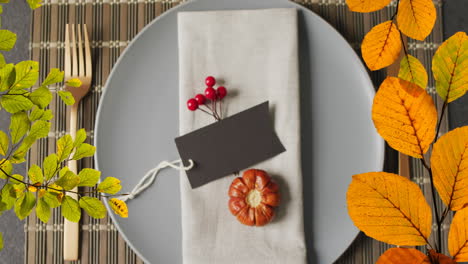 animation of autumn leaves over thanksgiving dinner place setting background