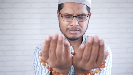 muslim man keep hand in praying gestures during ramadan, close up