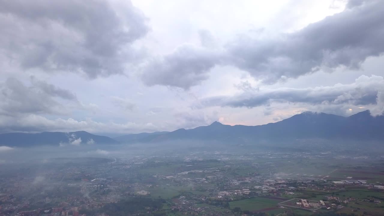 Video dari atas. Pemandangan udara drone terbang menembus awan. Pedesaan Italia di latar belakang.