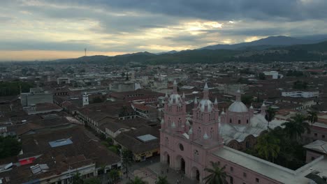 aerial view of a city with a pink church at sunset