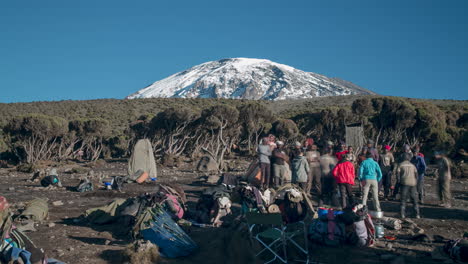 timelapse of camp tearing down then doing tipping ceremony then leaving with the porters and crew under mount kilimanjaro tanzania