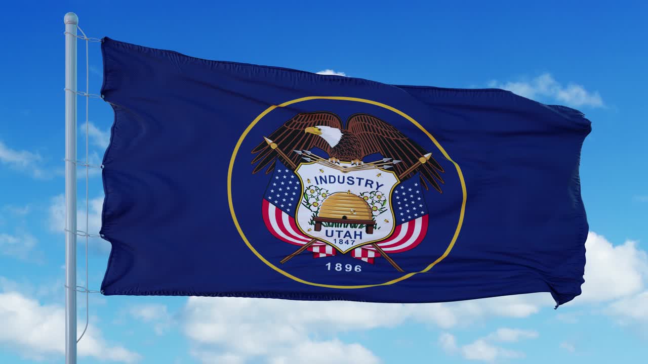 la bandera de utah en un asta de bandera ondeando en el viento, fondo de cielo azul. 4k