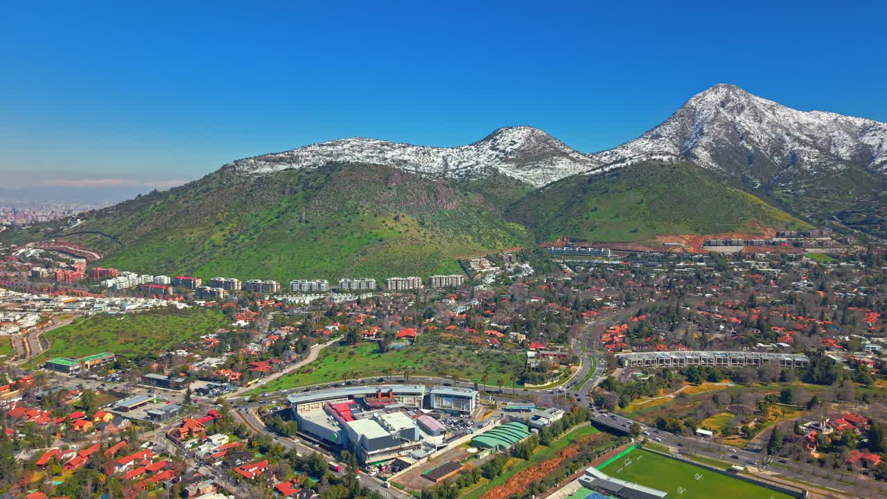 Aerial view of Los Trapenses with Manquehuito and Manquehue snowy hills above the sunny neighborhood