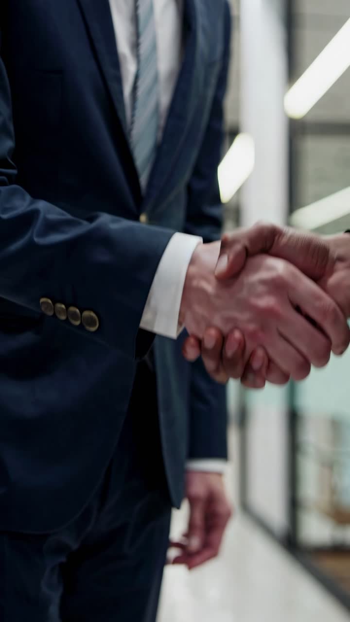 Primo piano di una stretta di mano tra due persone in abito, che simboleggia accordo e collaborazione