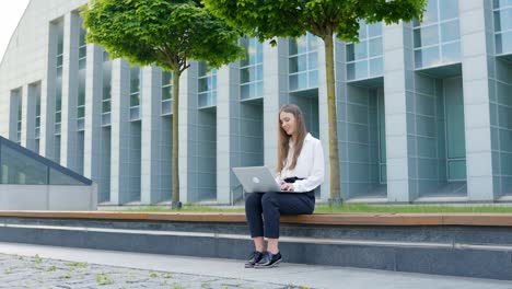 caucasian woman in a white blouse working on a laptop, in slow motion