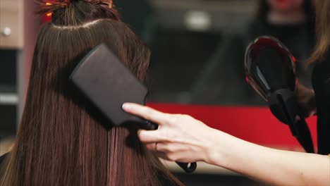 hairstylist straightening long brown hair