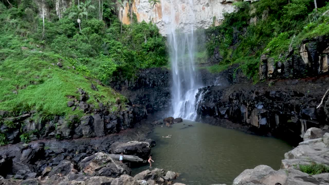 una cascada que desemboca en una serena piscina forestal