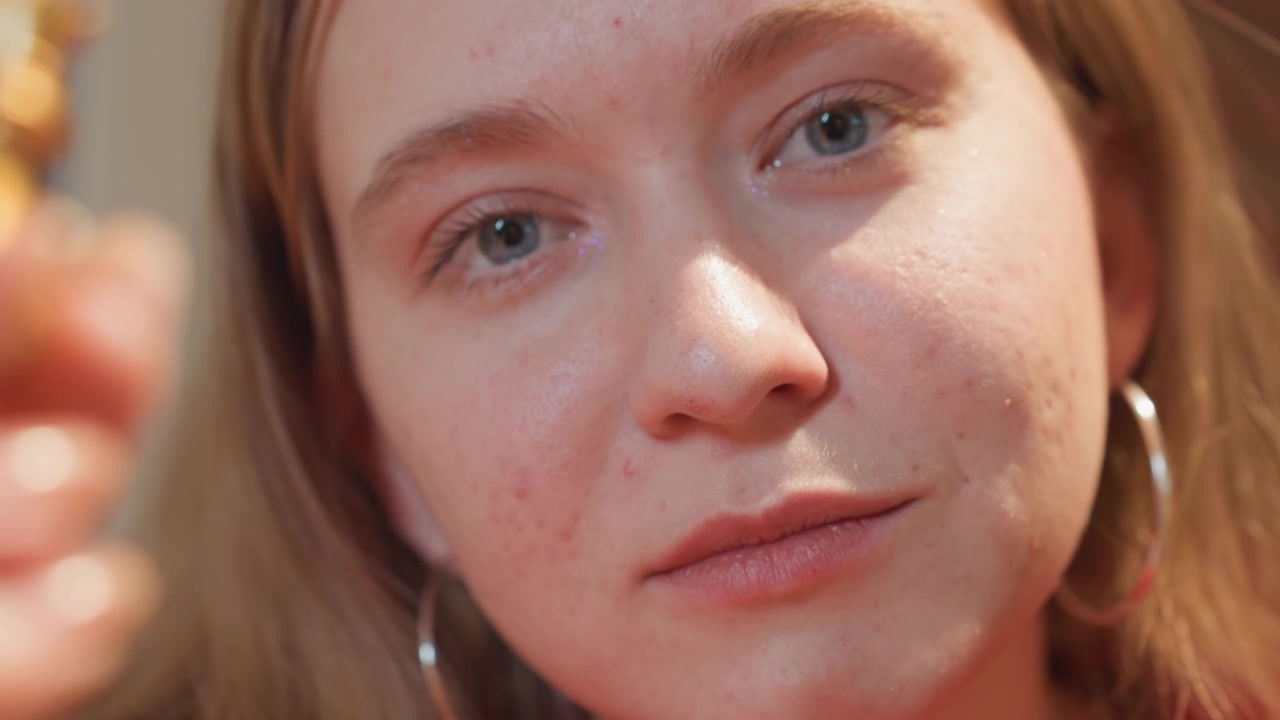 Giovane donna con espressione pensierosa che tiene in mano una regina degli scacchi dorata