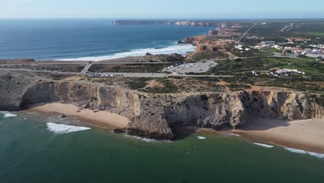 playa mareta en portugal, algunos surfistas en la bahía, disparos de drones con clima soleado