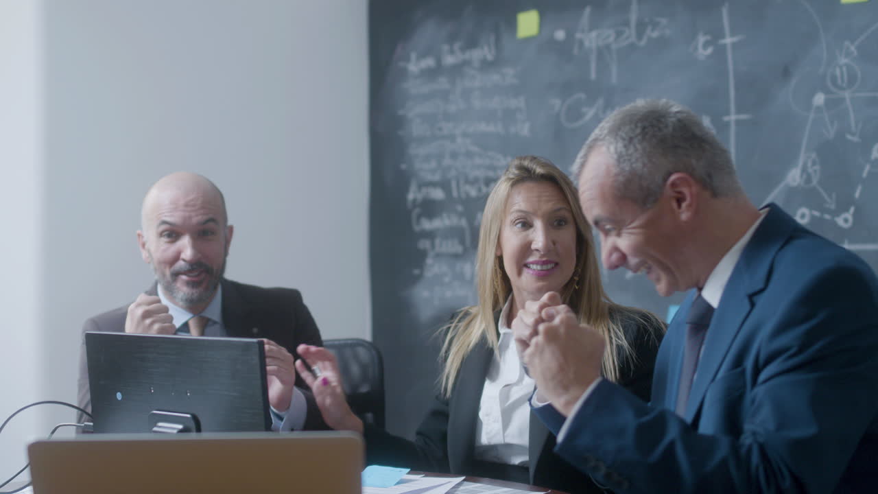 Business partners sitting at table in boardroom