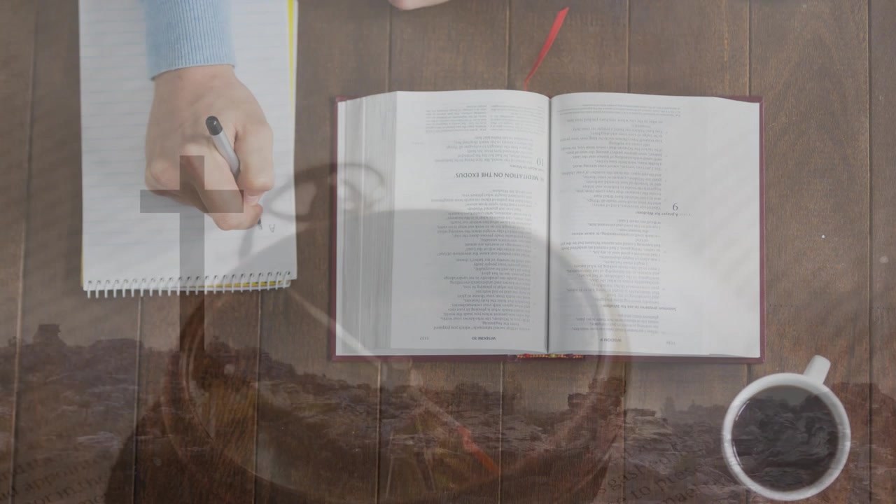 Mano destra che tocca una penna e scrive appunti su un quaderno a spirale, mentre le sovrapposizioni si spostano per lo studio.