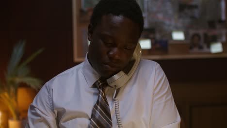 man talking on phone in a detective office
