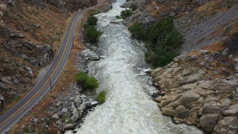 Carro-Aéreo-Rápido-Por-El-Río-Kern-En-La-Autopista-178-Desde-La-Represa-Del-Lago-Isabella-En-Bakersfield-Durante-Una-Inundación-Furiosa-Con-Agua-Turbulenta-Que-Corre-Con-Fuerza-Y-Cubre-árboles