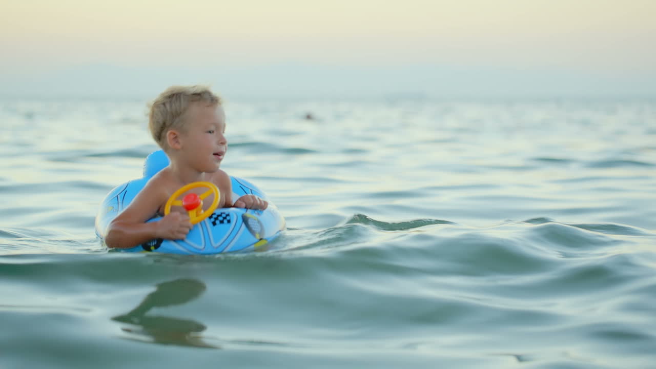 Boy with rubber ring swimming in sea