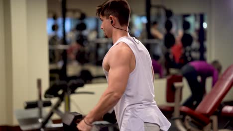 rear closeup of young bodybuilder doing dumbbell lateral raises