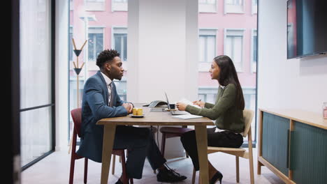 businesswoman interviewing male job candidate in meeting room