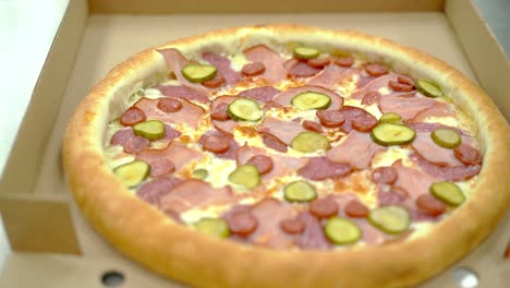 Koch-Legt-Gekochte-Pizza-Mit-Speck-Und-Geräucherter-Wurst-In-Eine-Kiste-Zur-Weiteren-Lieferung