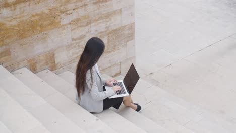 Vista-De-ángulo-Alta,-De,-Mujer,-En,-Computador-Portatil,-En,-Escaleras