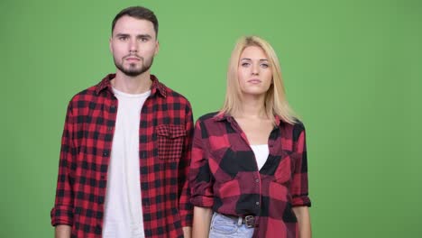 young couple covering mouth together as three wise monkeys concept