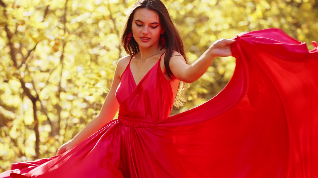 Capturing a Radiant Model Twirling in a Vibrant Red Dress Amidst a Glorious Golden Autumn Landscape, Showcasing Timeless Beauty and Elegance