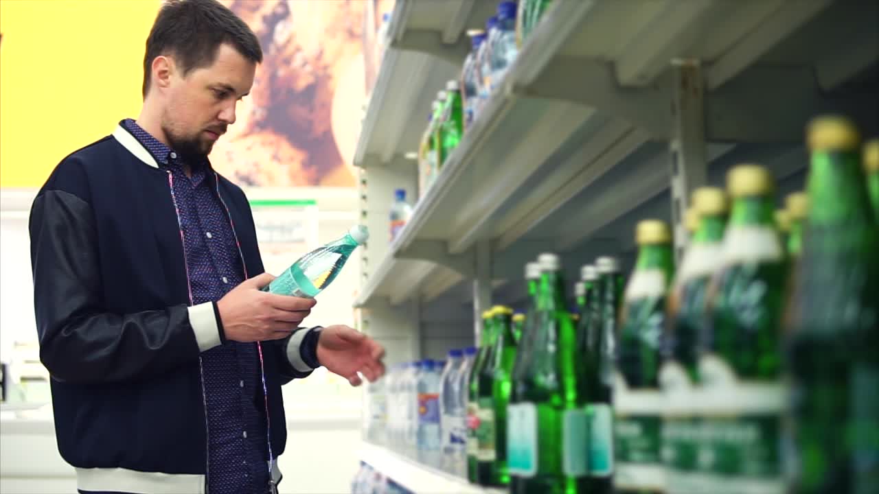 Homem comprando água em um supermercado