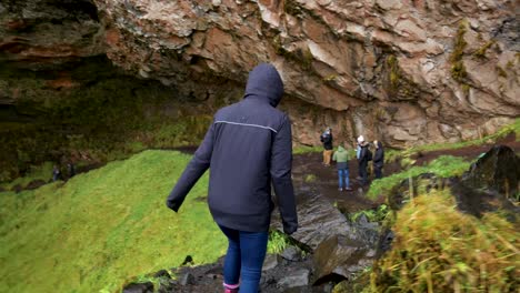 folgeaufnahme einer jungen frau hinter dem wasserfall