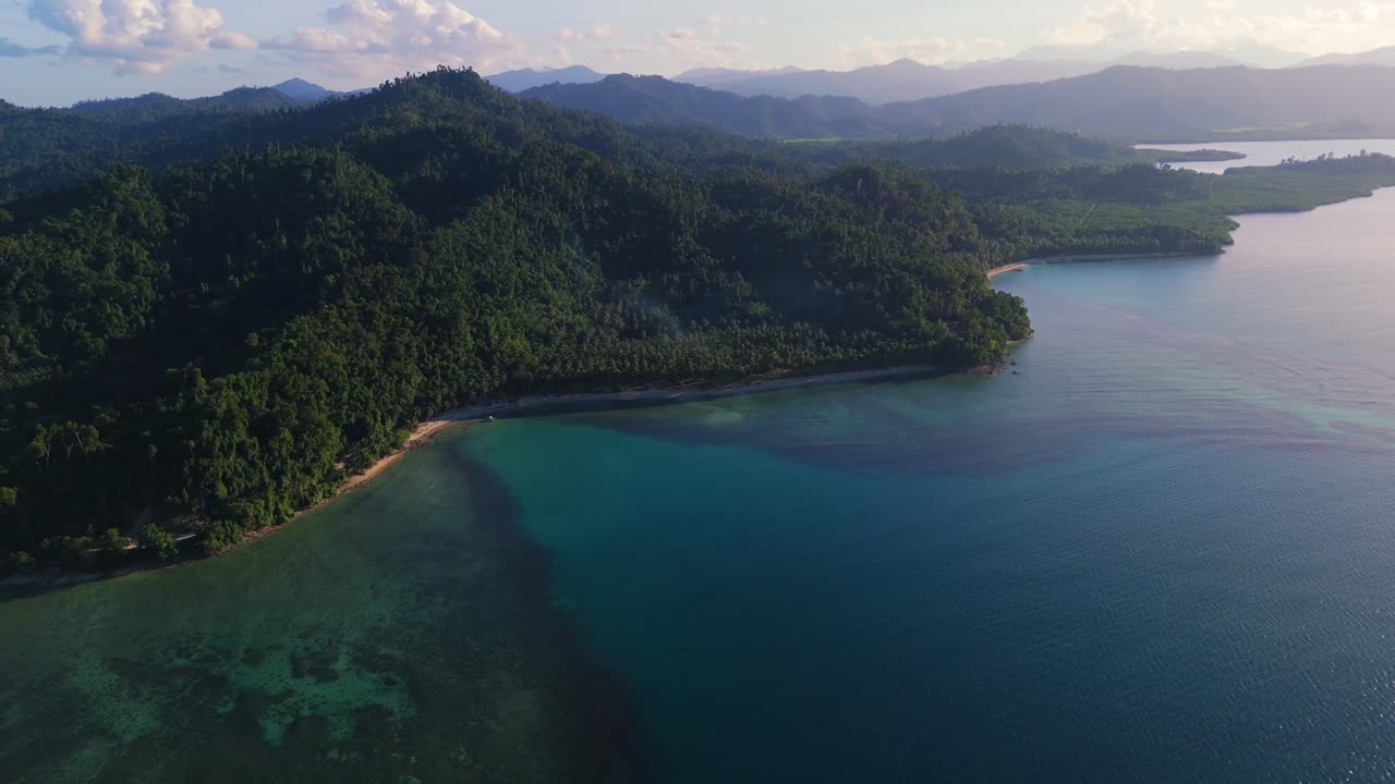Panorama aereo con drone della costa incontaminata color turchese e delle lussureggianti colline di foresta tropicale verde di Port Barton, San Vicente, Palawan. Cattura la bellezza naturale dell'isola delle Filippine.