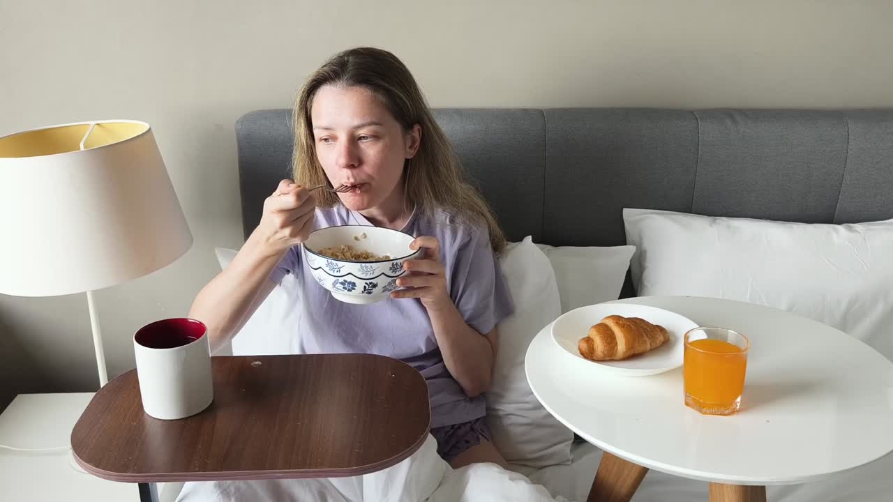 침대에서 아침을 먹는 여자