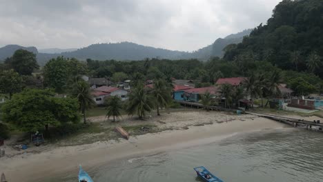 Low-tropical-flight-to-quaint-rustic-beach-resort-on-Pulau-Tuba,-MAL