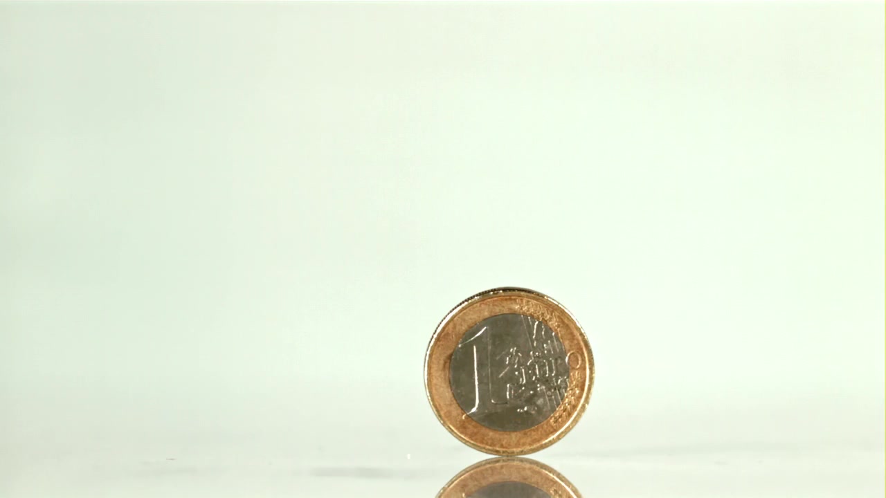 Primo piano di una moneta da un euro che gira sul suo bordo
