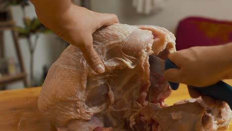 cortar la carne de pavo con un cuchillo de cocina en una tabla cortada de madera