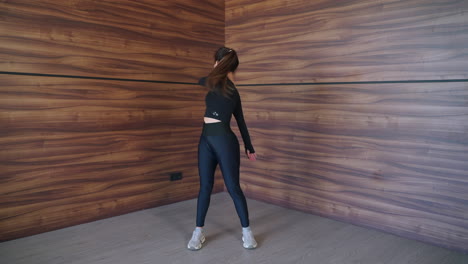 mujer estirándose en un gimnasio en casa