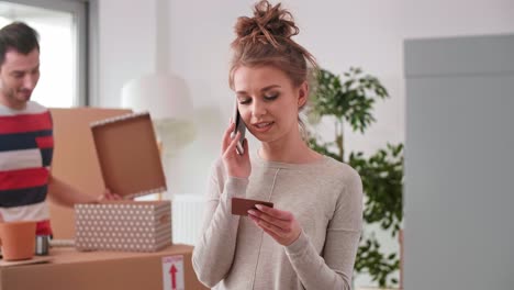 smiling woman using phone while moving house