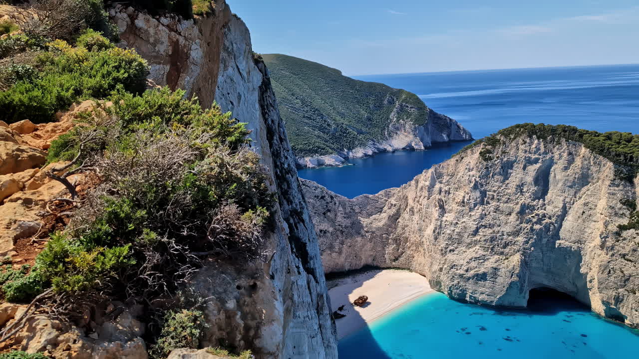 vista épica en la playa blanca con el naufragio navajo y el agua azul clara por las montañas, grecia