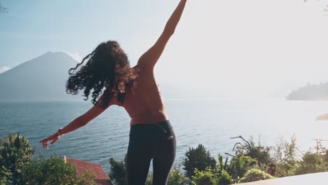 atractiva mujer india bailando contra el sol brillante y la montaña del volcán