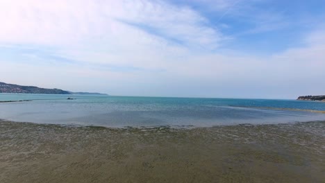 Landscape-view-at-wide-wet-sands,-descending-aerial-shot