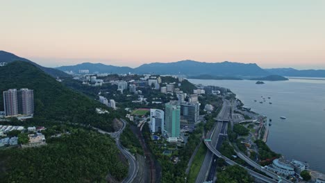 aerial drone forward moving shot over the chinese university of hong kong , hyatt regency and cuhk medical centre in hong kong at sunrise