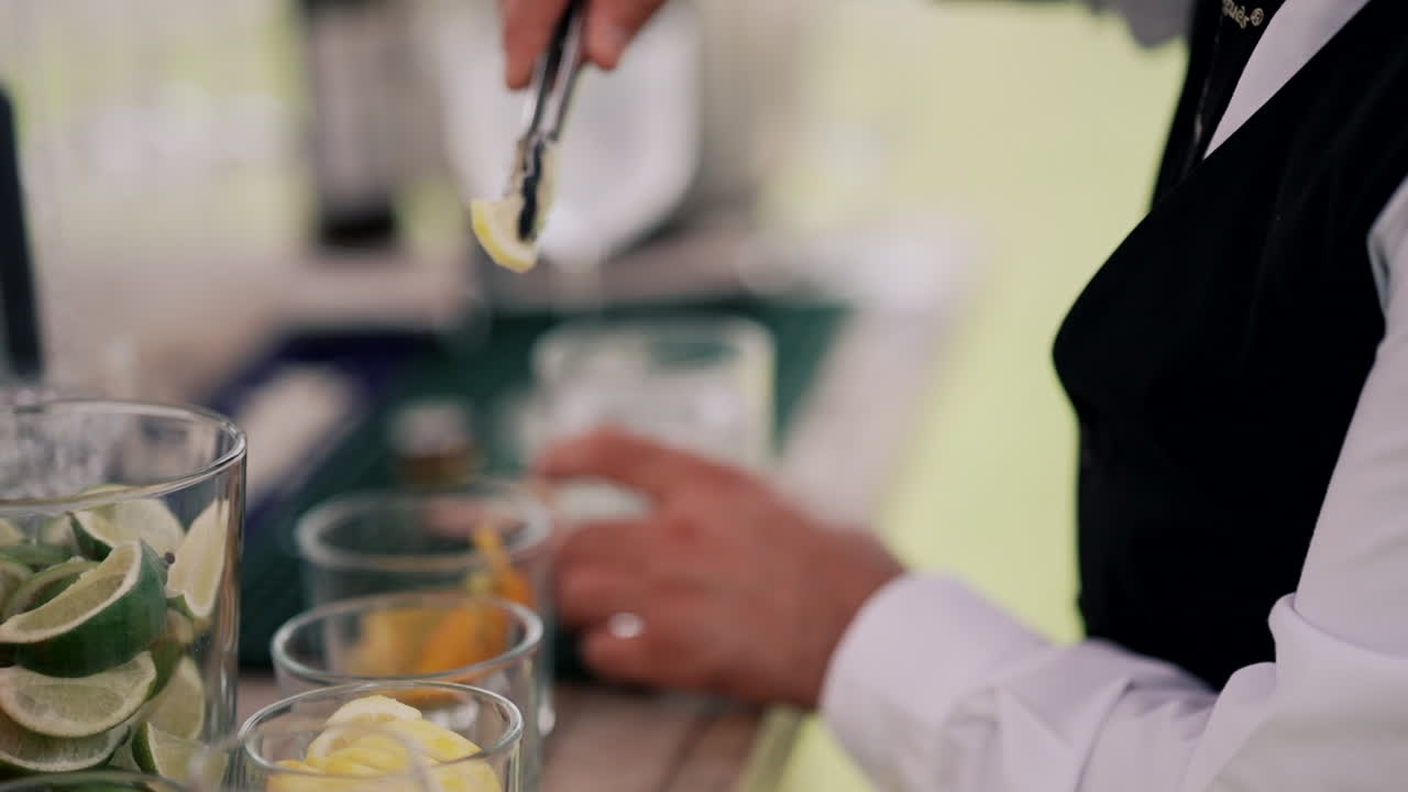 el barman agita una bebida en un vaso de cristal.