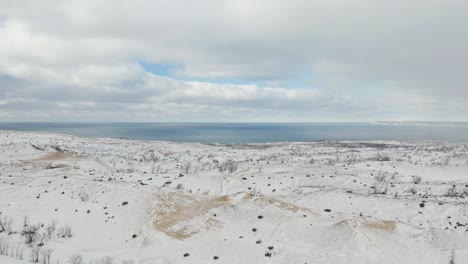 drone reveals snow covered sand dunes at sleeping bear dunes national lakeshore