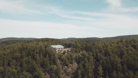 gorgeous forest covered hill side on a sunny day from a 4k drone in the middle of the gatineau hills of le belvédère in wakefield, quebec, canada