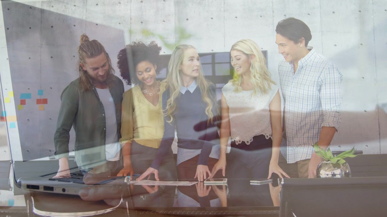 Team leunt over een bureau, een typende overlay verschuift om een laptop te onthullen terwijl ze een bedrijfspresentatie beoordelen