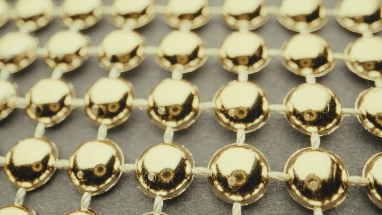 Close-up of Golden Beads on a Grid Pattern