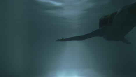 girl swims to the surface under water