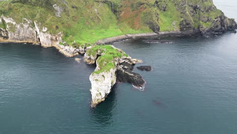 Toma-Aérea-De-Paralaje-De-Impresionantes-Acantilados-En-Una-Hermosa-Costa-Desde-El-Castillo-De-Kibane-En-Irlanda-Del-Norte-A-Lo-Largo-De-La-Carretera-Costera-De-La-Calzada-Gigante-Durante-Un-Emocionante-Viaje-Por-El-País