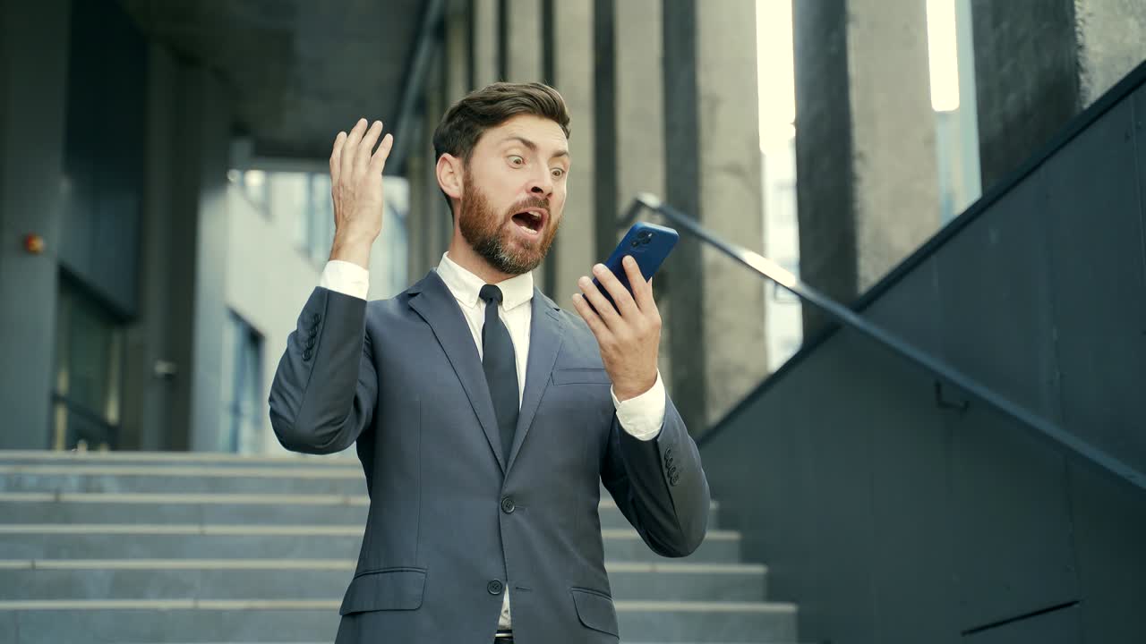 un uomo d'affari arrabbiato che piange parlando al telefono fuori. un uomo di affari che urla fuori.