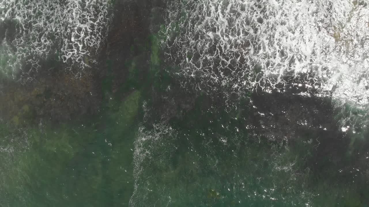 Aerial View of Ocean Waves Crashing on Rocky Coast