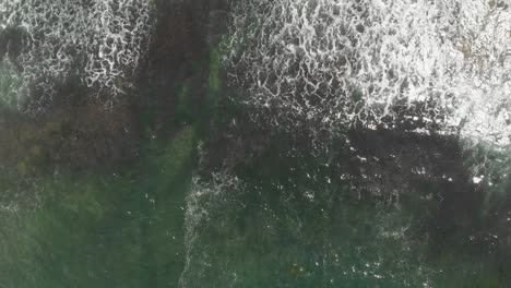 aerial view of ocean waves crashing on rocky coast